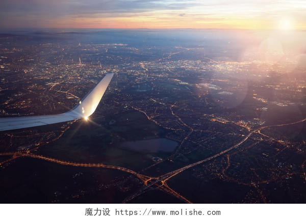 日落时从降落在城市窗外的飞机上看风景